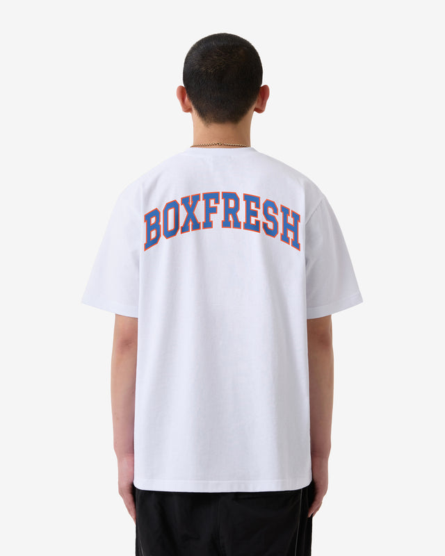 Person trägt ein weißes T-Shirt mit dem Aufdruck „BOXFRESH“ auf der Rückseite vor weißem Hintergrund