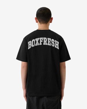 Person wearing a black t-shirt with 'BOXFRESH' printed on the back against a white background