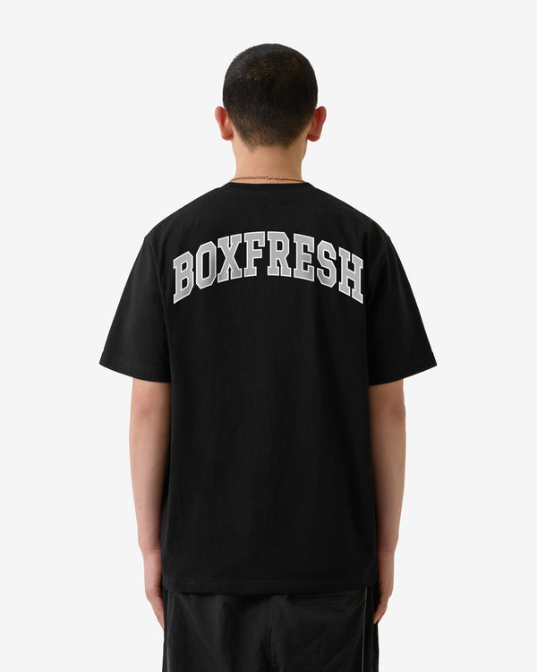 Person wearing a black t-shirt with 'BOXFRESH' printed on the back against a white background