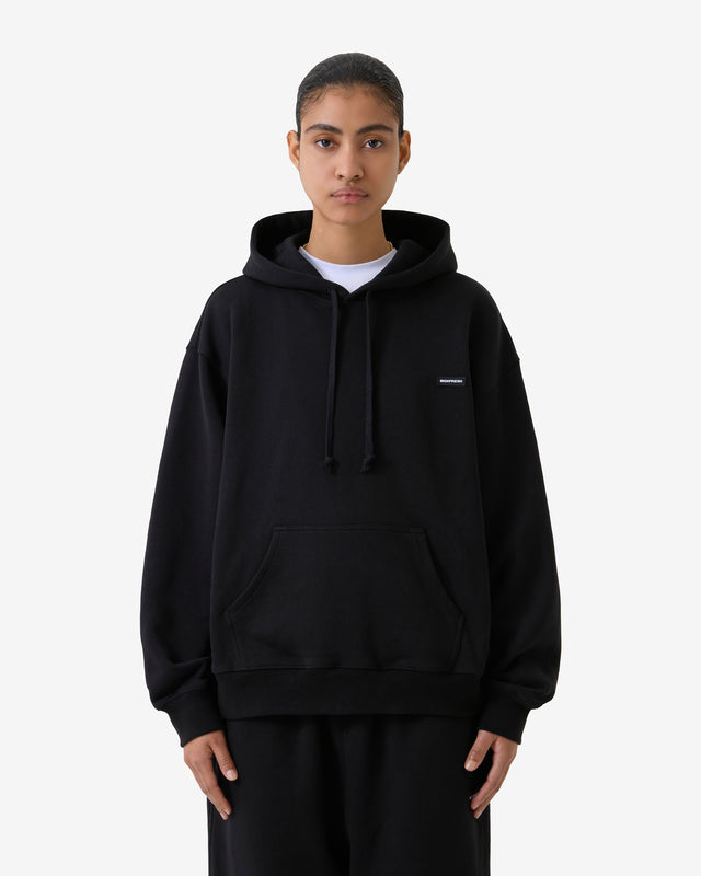 Front view of a model wearing a black hoodie. 