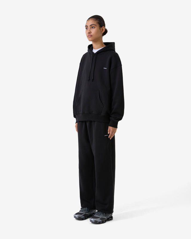 Side view of a model wearing a matching hoodie and pants as a set. 