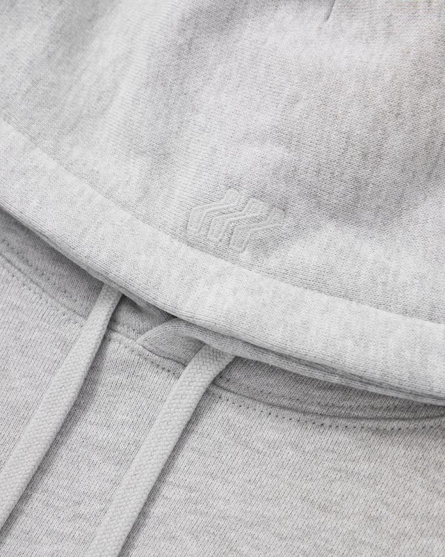 Close-up of a gray sweatshirt with a brand logo on the chest.