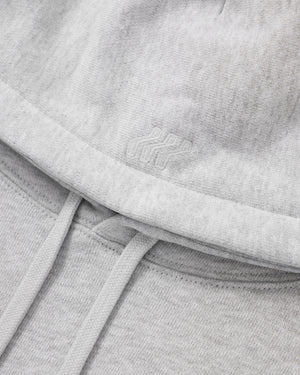 Close-up of a gray sweatshirt with a brand logo on the chest.