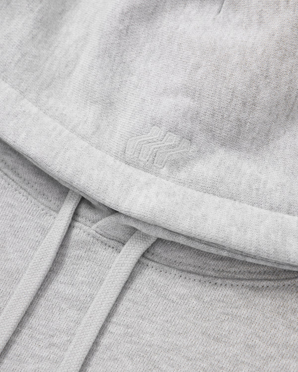 Close-up of a gray sweatshirt with a brand logo on the chest.