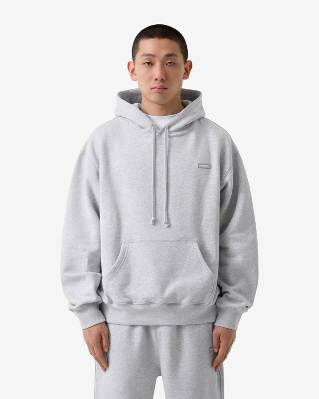 Person wearing a gray hoodie and pants on a white background