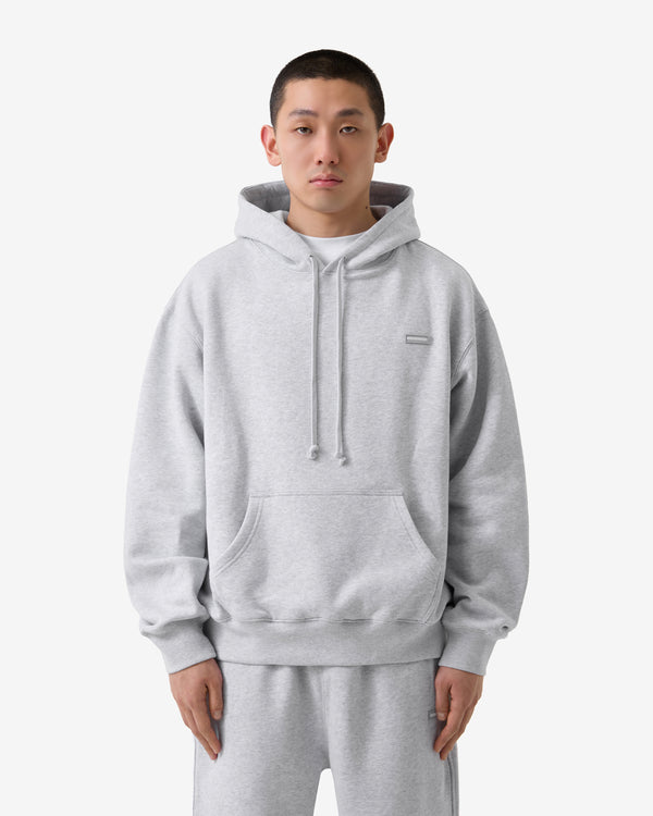 Person wearing a gray hoodie and pants on a white background