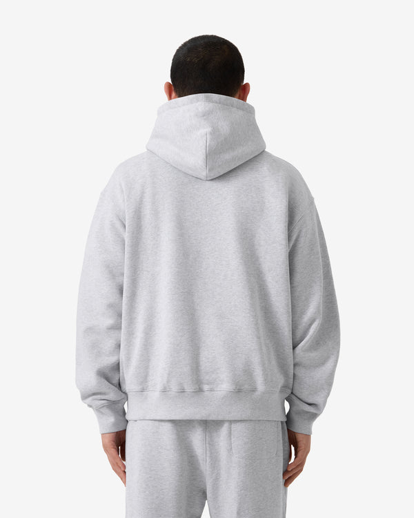 Person wearing a gray hoodie and pants on a white background