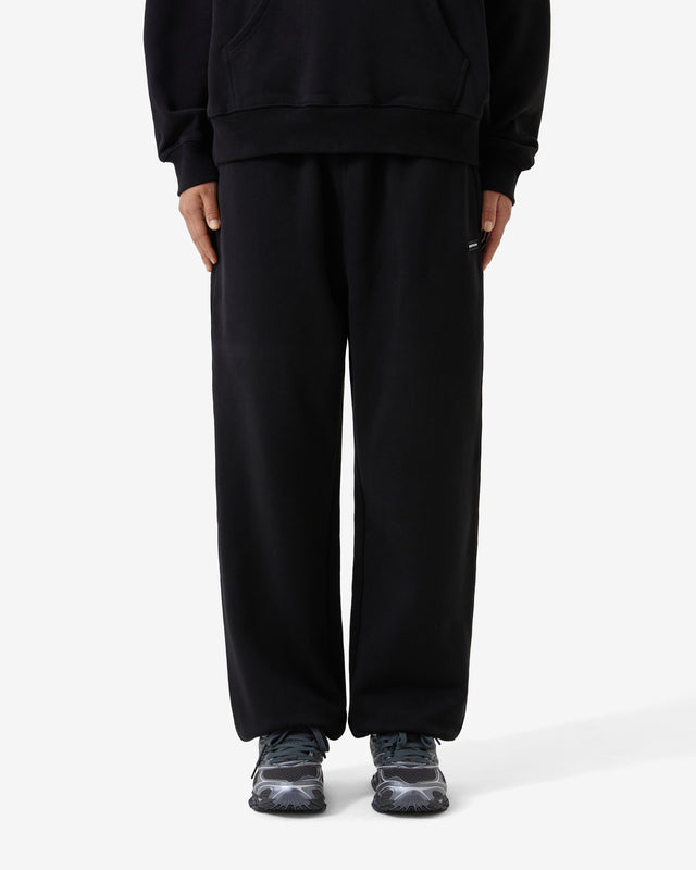 Person wearing a black tracksuit on a white background