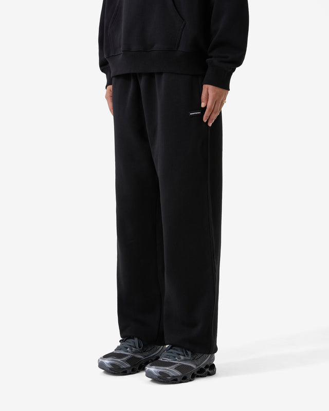 Person wearing a black outfit with wide-leg pants on a white background