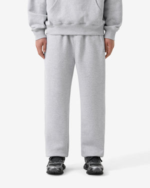 Person wearing a gray tracksuit on a white background