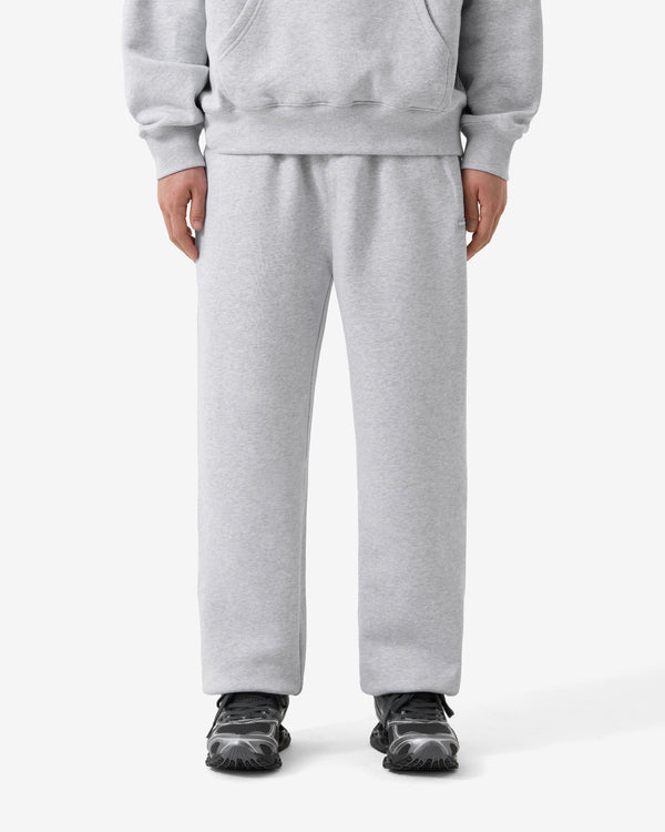Person wearing a gray tracksuit on a white background