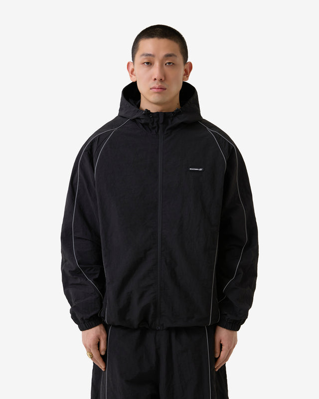 Person wearing a black jacket with a brand logo on a white background