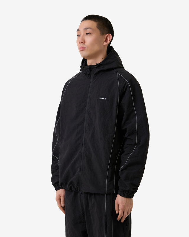 Person wearing a black jacket with a brand logo on a white background