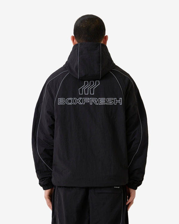 Person trägt einen schwarzen Kapuzenpullover mit „BOXFRESH“-Logo auf der Rückseite vor weißem Hintergrund