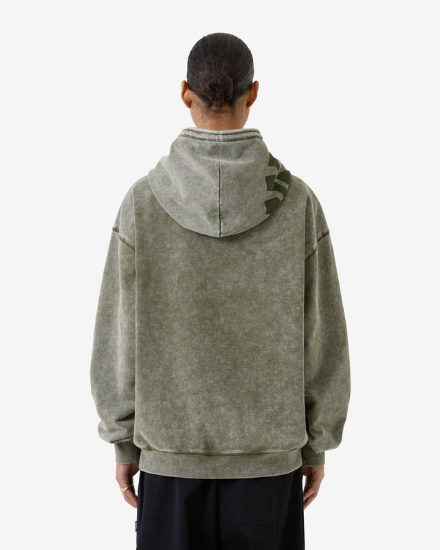 Person wearing a green hoodie with a brand logo on the back against a white background