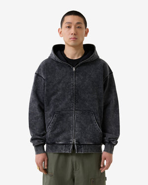 Person wearing a black distressed hoodie on a white background