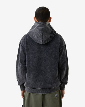 Person wearing a dark gray hoodie with a visible brand logo on a white background