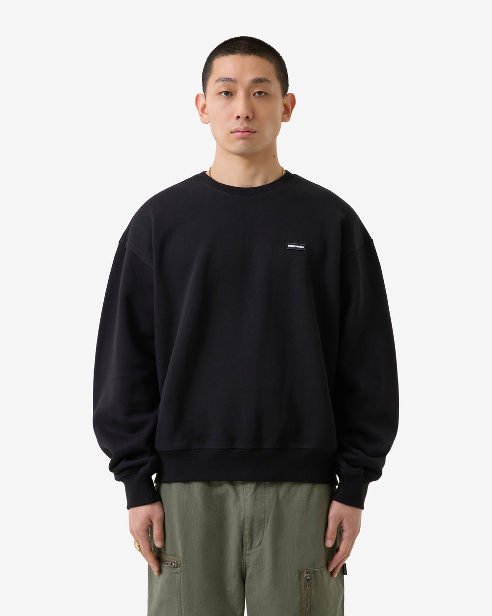 Black sweatshirt with a small white logo on a light gray background