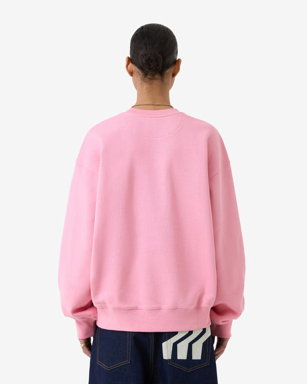 Person trägt ein rosa Sweatshirt mit weißem Hintergrund