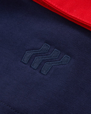 Marineblauer Stoff mit blauem gesticktem Logo und rotem Stoff in der Ecke