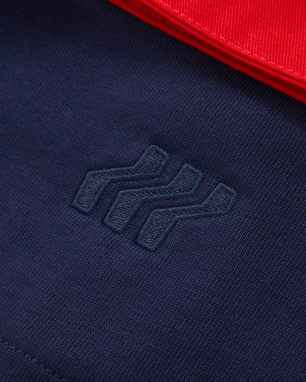 Marineblauer Stoff mit blauem gesticktem Logo und rotem Stoff in der Ecke