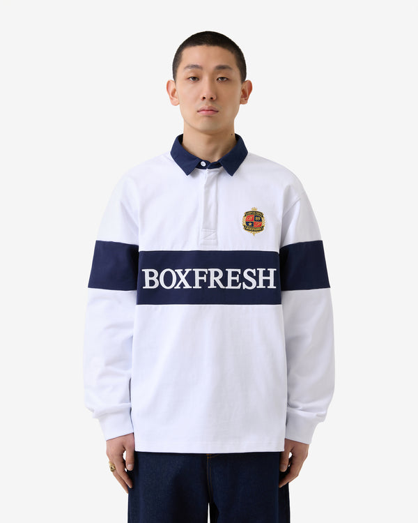 Person trägt ein weiß-marineblau gestreiftes Hemd mit „BOXFRESH“-Logo auf weißem Hintergrund