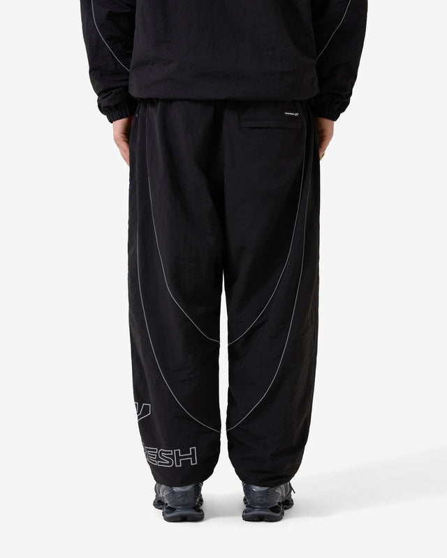 Person wearing black pants with white text on a white background