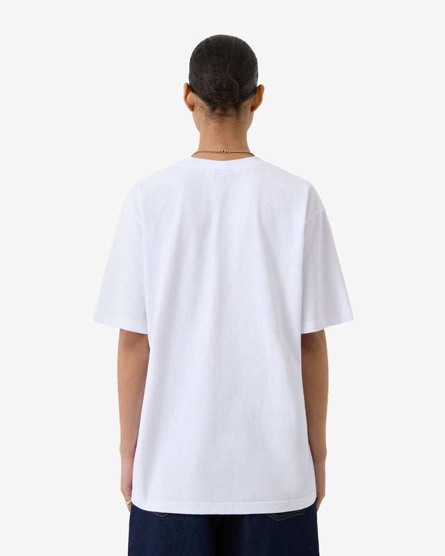 Person trägt ein schlichtes weißes T-Shirt auf weißem Hintergrund