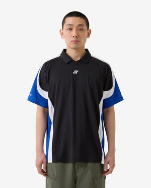 Person trägt ein schwarzes Poloshirt mit blauen und weißen Seiteneinsätzen auf weißem Hintergrund