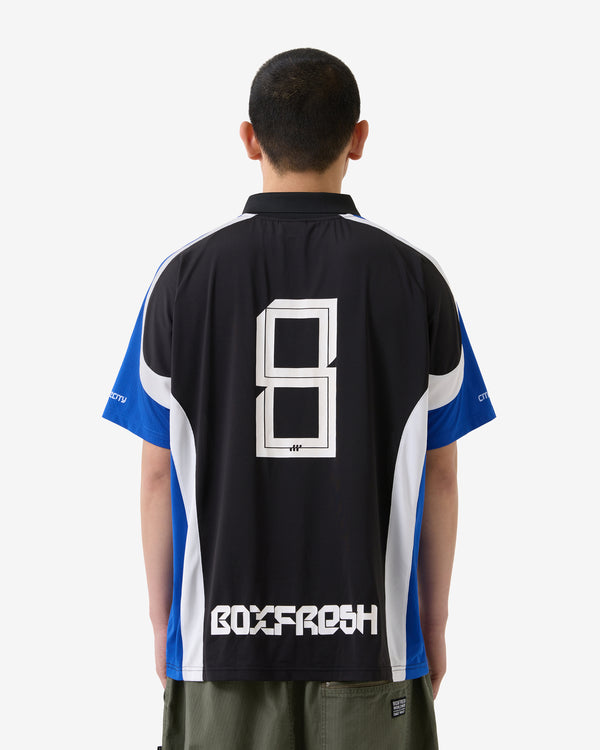 Person trägt ein schwarz-blaues Sporttrikot mit „BOXFRESH“-Logo auf der Rückseite.