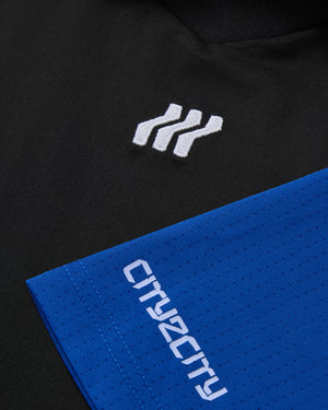 Nahaufnahme eines schwarz-blauen Kleidungsstücks mit Logo und Text.