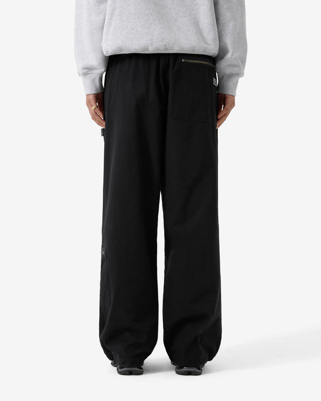 Person wearing black pants and a gray sweatshirt on a white background