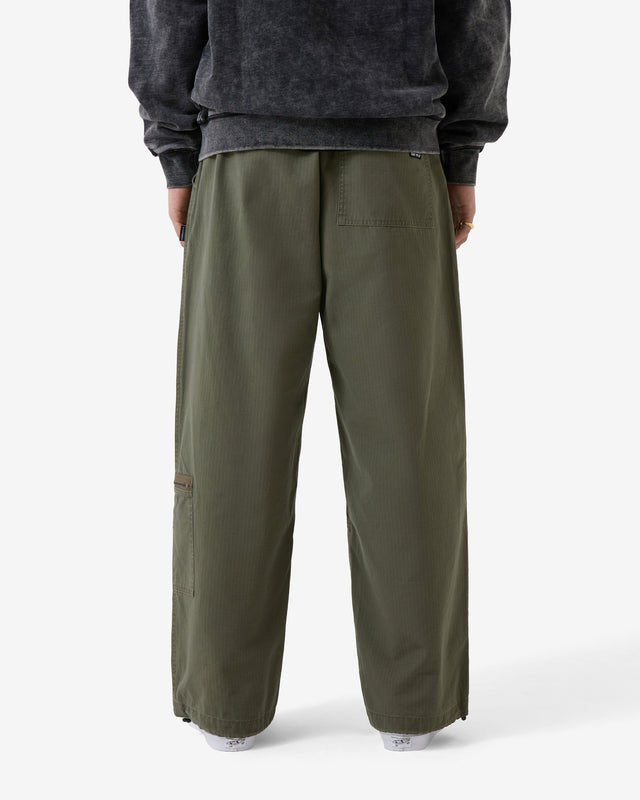 Person wearing olive green pants and a dark gray sweatshirt on a white background