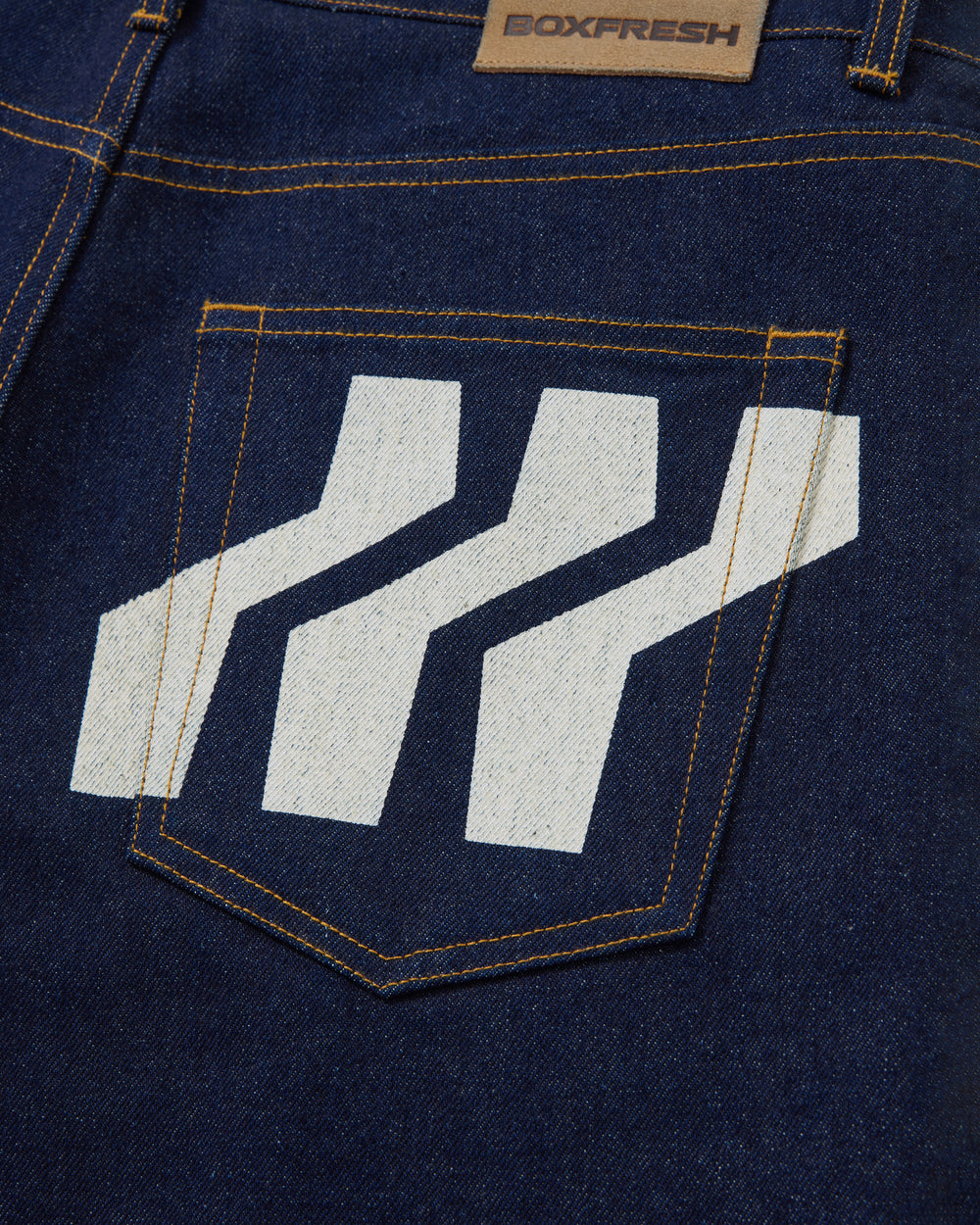 Navy blue jeans with a white logo on the back pocket against a white background