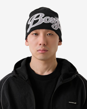 Person wearing a black beanie with 'BOY' logo on a white background